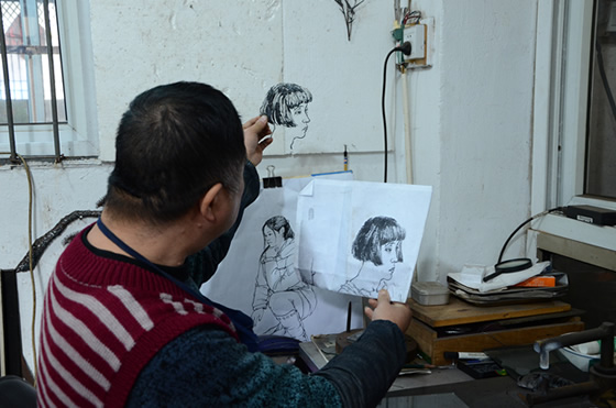 徽藝坊鐵畫(huà)大師凌曉華正在對(duì)比打制的人物像