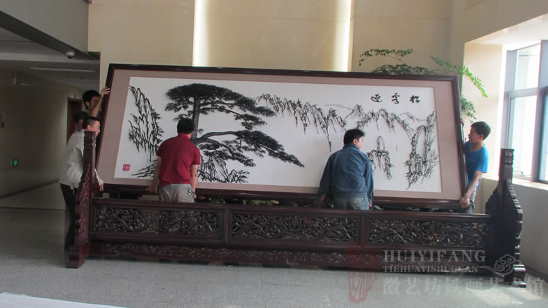 昆明長(zhǎng)水國(guó)際機(jī)場(chǎng)定制的辦公樓大廳大型紅木迎客松鐵畫(huà)屏風(fēng)-正在安裝鐵畫(huà)屏風(fēng)
